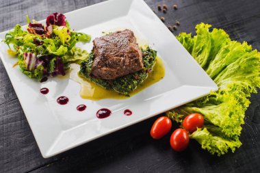 Kızarmış parça et otlar ve baharatlar ahşap arka plan üzerinde