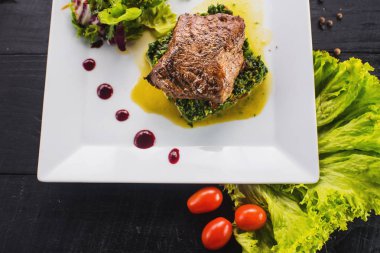 Kızarmış parça et otlar ve baharatlar ahşap arka plan üzerinde