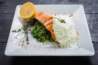 Lezzetli balık biftek sosu ve ahşap arka plan üzerinde otlar