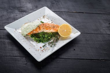 Lezzetli balık biftek sosu ve ahşap arka plan üzerinde otlar