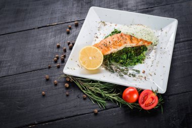 Lezzetli balık biftek sosu ve ahşap arka plan üzerinde otlar