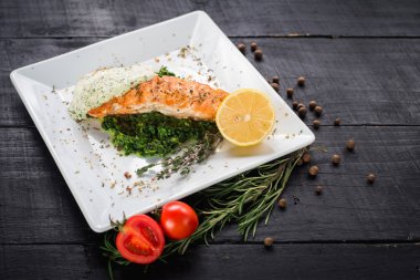 Lezzetli balık biftek sosu ve ahşap arka plan üzerinde otlar