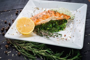 Lezzetli balık biftek sosu ve ahşap arka plan üzerinde otlar