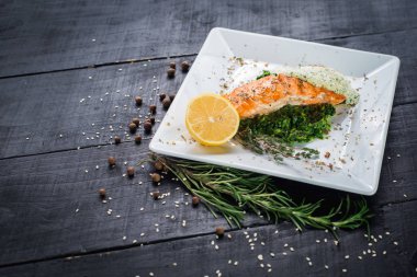 Lezzetli balık biftek sosu ve ahşap arka plan üzerinde otlar