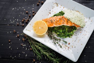 Lezzetli balık biftek sosu ve ahşap arka plan üzerinde otlar