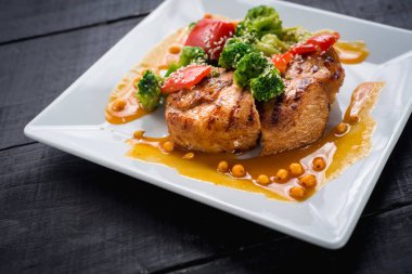 Ahşap arka plan üzerinde sebze ve mercimek soslu lezzetli kızarmış tavuk eti