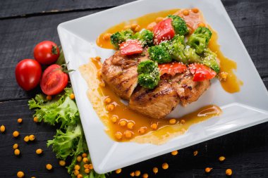 Ahşap arka plan üzerinde sebze ve mercimek soslu lezzetli kızarmış tavuk eti