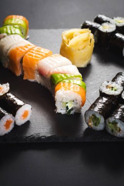 Bir dizi farklı suşi havyar ile siyah arka plan üzerine alır.