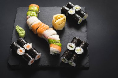 Bir dizi farklı suşi havyar ile siyah arka plan üzerine alır.