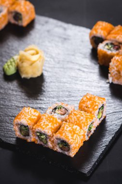 Bir dizi farklı suşi havyar ile siyah arka plan üzerine alır.