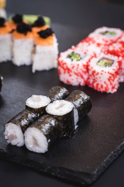 Bir dizi farklı suşi havyar ile siyah arka plan üzerine alır.