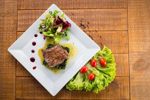 Kızarmış parça et otlar ve baharatlar ahşap arka plan üzerinde