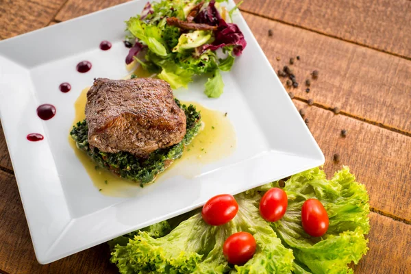 Kızarmış parça et otlar ve baharatlar ahşap arka plan üzerinde