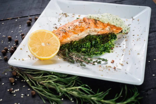 Lezzetli balık biftek sosu ve ahşap arka plan üzerinde otlar