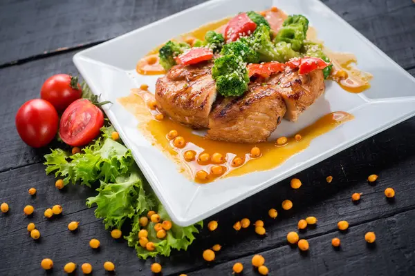 Ahşap arka plan üzerinde sebze ve mercimek soslu lezzetli kızarmış tavuk eti