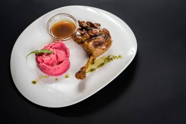 Kızarmış tavuk shin sos ve pembe patates püresi siyah arka plan üzerine