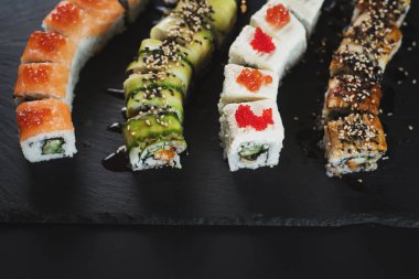 Siyah arkaplanda farklı suşi çeşitleri
