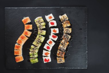 Siyah arkaplanda farklı suşi çeşitleri