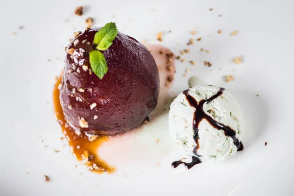 A dessert with caramelized pear and ice on black background