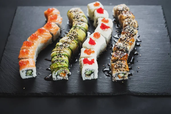 Siyah arkaplanda farklı suşi çeşitleri