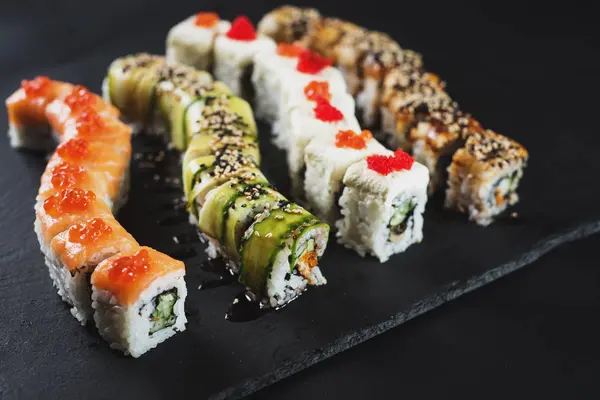 Siyah arkaplanda farklı suşi çeşitleri