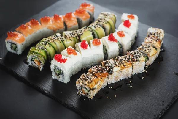 Siyah arkaplanda farklı suşi çeşitleri