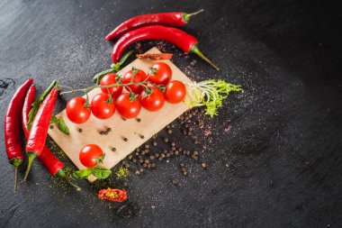 Siyah arka plan üzerine baharat ile taze kiraz domates