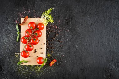 Taze domates ve siyah arka plan üzerine baharat. Üstten görünüm. Kopya alanı
