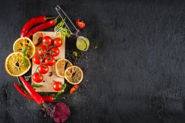 Taze domates ve siyah arka plan üzerine baharat. Üstten görünüm. Kopya alanı