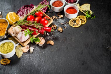 Siyah arka plan üzerine ham ve kuru sebzeli farklı baharatlar. Üstten görünüm. boş alan