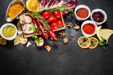 Siyah arka plan üzerine ham ve kuru sebzeli farklı baharatlar. Üstten görünüm. boş alan