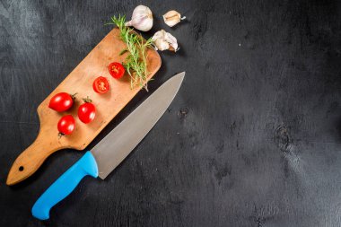 Siyah arka plan üzerine kesilmiş gemide baharat ile kiraz domates. Üstten görünüm. Kopya alanı