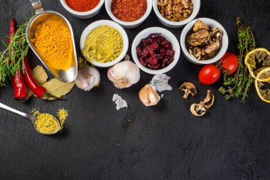 Siyah arka plan üzerine ham ve kuru sebzeli farklı baharatlar. Üstten görünüm. kopya alanı