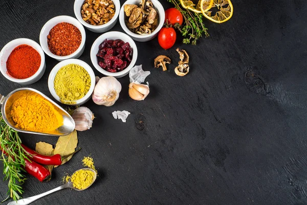 Siyah arka plan üzerine ham ve kuru sebzeli farklı baharatlar. Üstten görünüm. boş alan