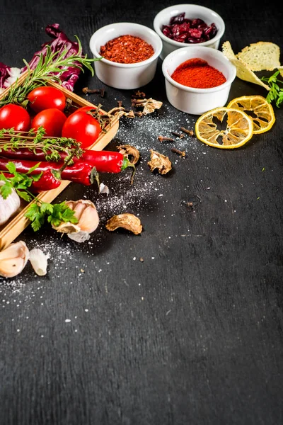 Siyah arka plan üzerine ham ve kuru sebzeli farklı baharatlar. Üstten görünüm. kopya alanı