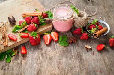 Çilekli meyve suları ve ahşap arka planda bir sürü çilek. Üst Manzara. Boşluğu kopyala