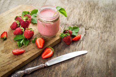 Çilekli meyve suları ve ahşap arka planda bir sürü çilek. Üst Manzara. Boşluğu kopyala