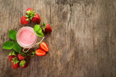 Ahşap arka planda cam kaplı çilekli içecekler. Üst Manzara. Boşluğu kopyala