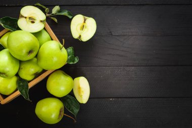 Siyah ahşap arka planda ahşap kutuda lezzetli ve taze yeşil elmalar. Üst Manzara. Boşluğu kopyala