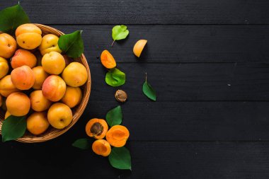 Siyah ahşap arka planda tatlı olgun kayısılar. Boşluğu kopyala