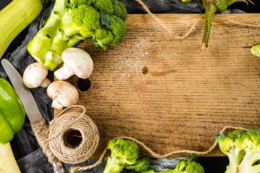 Ahşap arka planda bir sürü yeşil olgun sebze var. Boşluğu kopyala