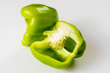 Beyaz arka planda olgun yeşil biber kesiği