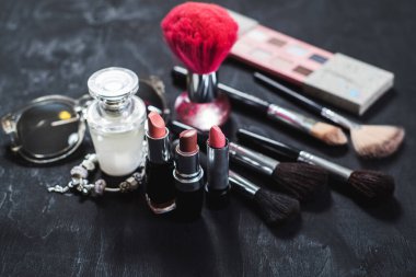 Kadın aksesuarları ve siyah arka planda kozmetik yatakları. Üst Manzara. Boşluğu kopyala