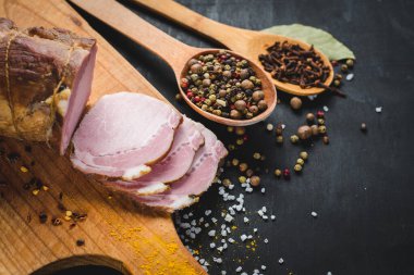 Siyah arka planda baharatlı lezzetli füme jambon.