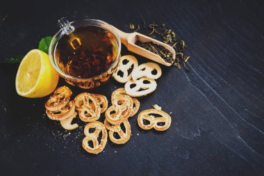 Siyah arka planda bir fincan meyve çayı ve kurabiye. Boşluğu kopyala
