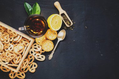Siyah arka planda bir fincan meyve çayı ve kurabiye. Boşluğu kopyala