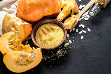 Siyah ahşap arka planda kesilmiş büyük çiğ balkabağı. Boşluğu kopyala