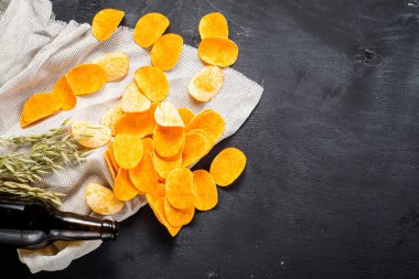 Siyah arka planda bira ile patates cipsi. Boşluğu kopyala