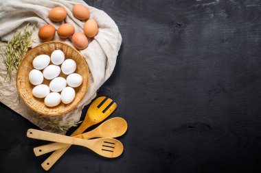 Siyah ahşap arka planda sepetteki tavuk yumurtaları. Boşluğu kopyala