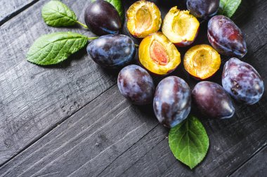 Siyah arka planda bir sürü taze erik. Boşluğu kopyala